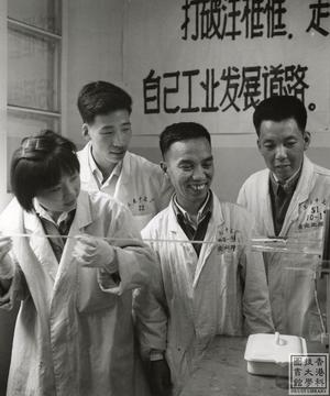 A young woman with rod in hand standing with three men
